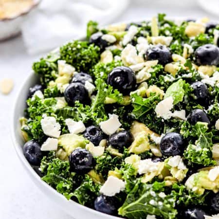 The tossed blueberry kale salad in a large serving bowl.