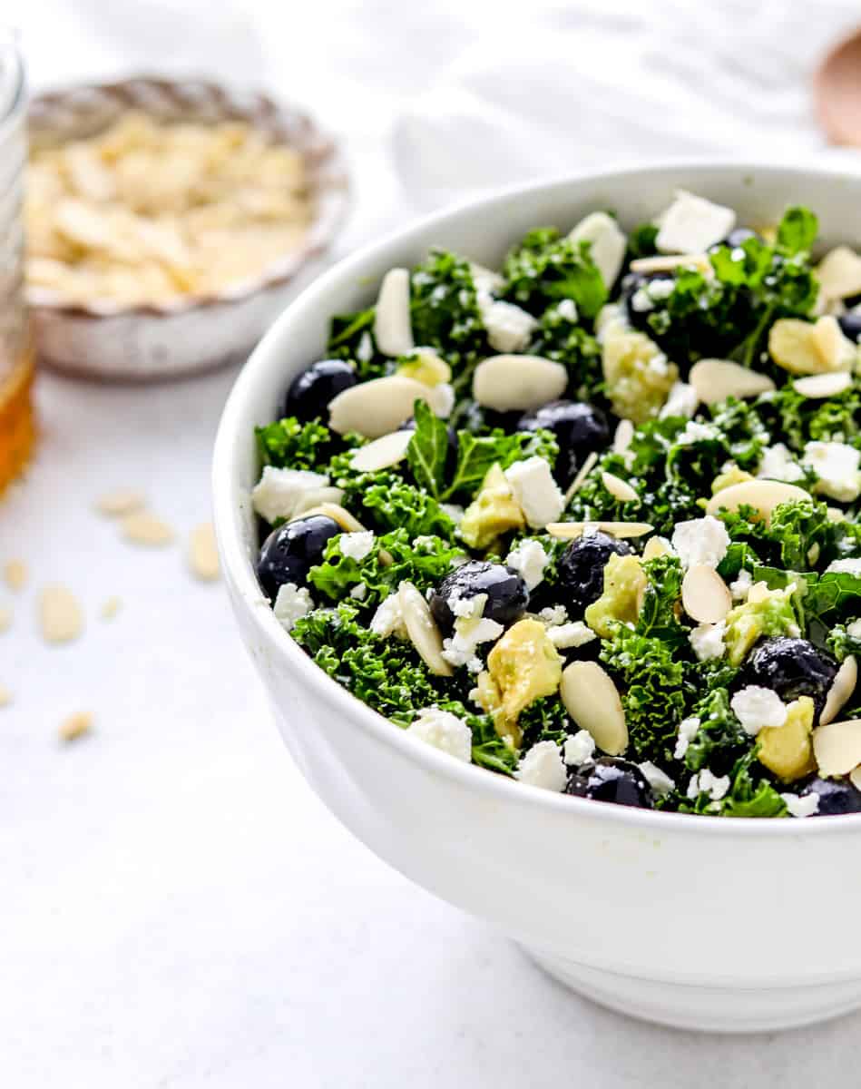 Kale avocado salad served in a large white bowl.
