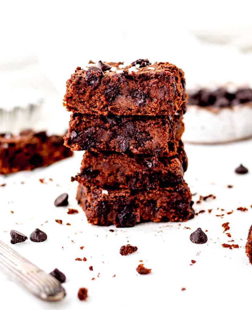 stack of four fudgy chickpea brownies with chocolate chips.