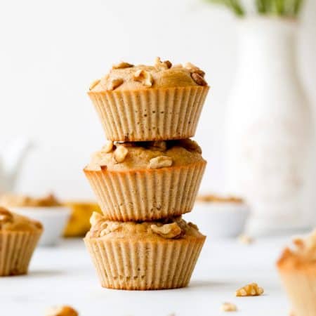 Three Greek yogurt banana muffins stacked on top of each other.