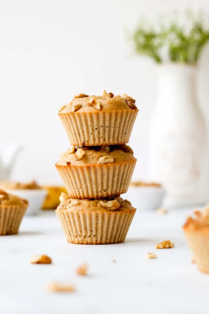 Three Greek yogurt banana muffins stacked on top of each other.