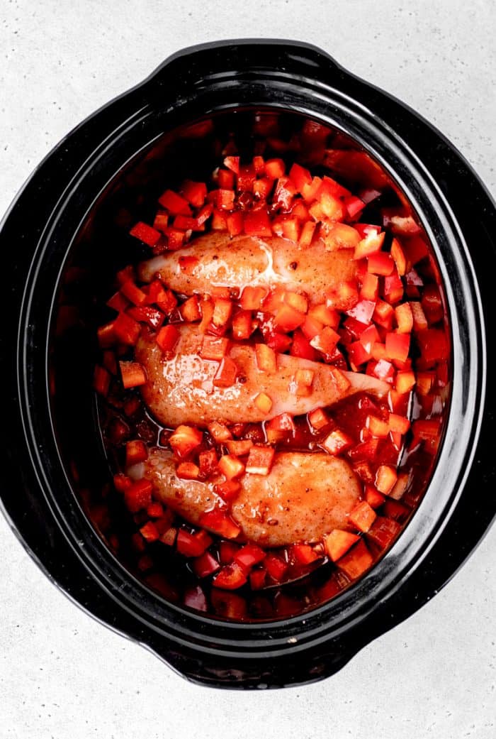 Cooked buffalo chicken breasts in a slow cooker.