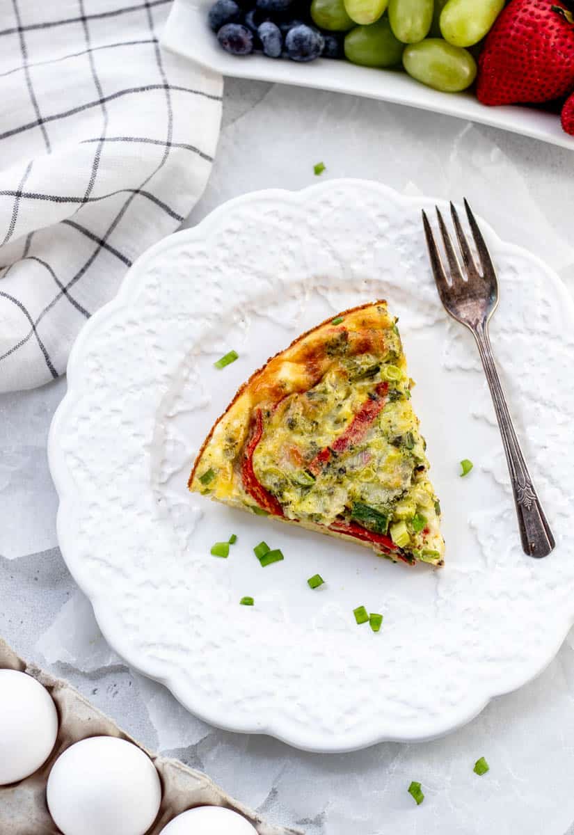 Overhead shot of a slice of crustless quiche on a plate with a fork.