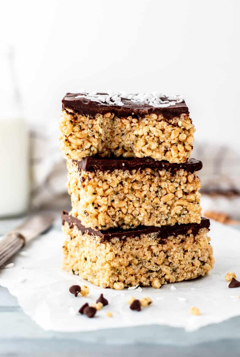 Three chocolate covered peanut butter rice krispie treats stacked on top of each other.