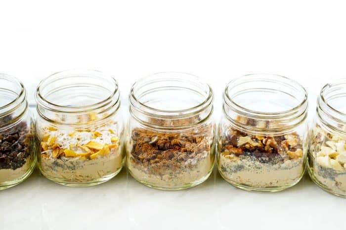 Jars filled with different flavours of vanilla protein overnight oats.