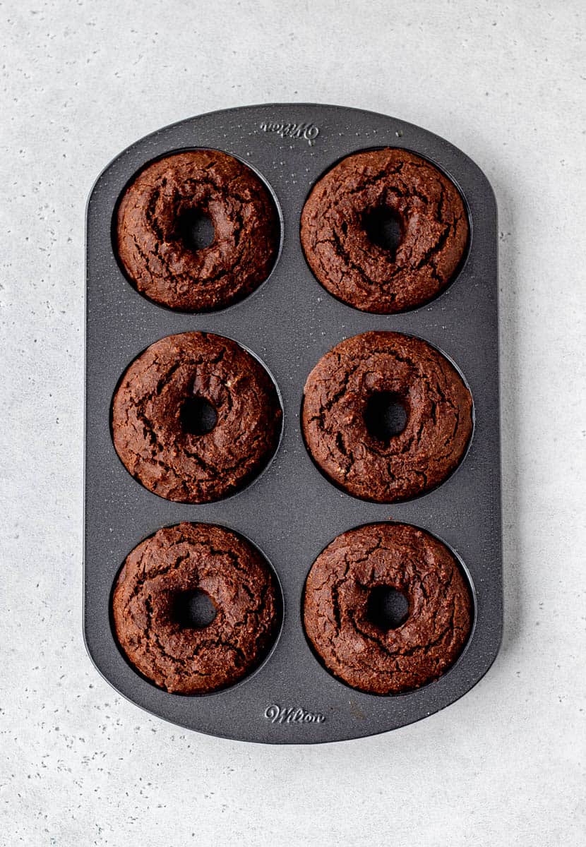 Chocolate baked donuts in a donut pan.