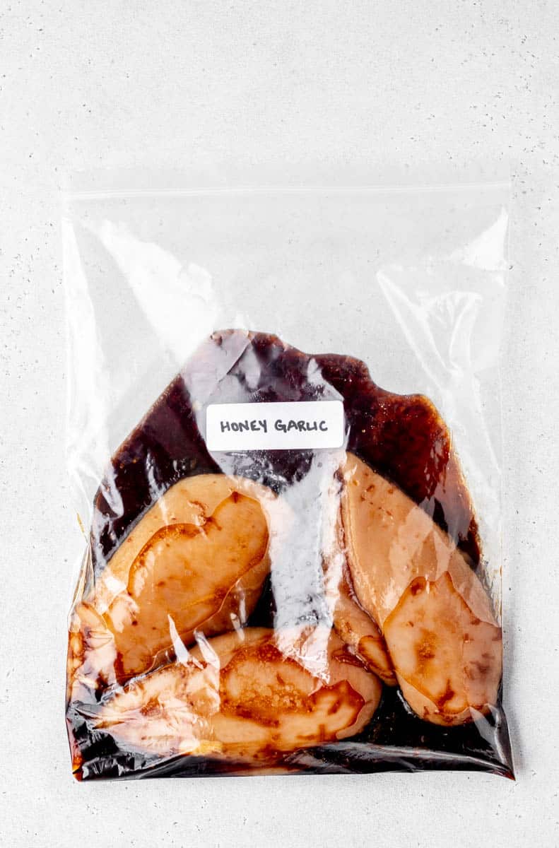 Honey garlic chicken being marinated in freezer bag with label.
