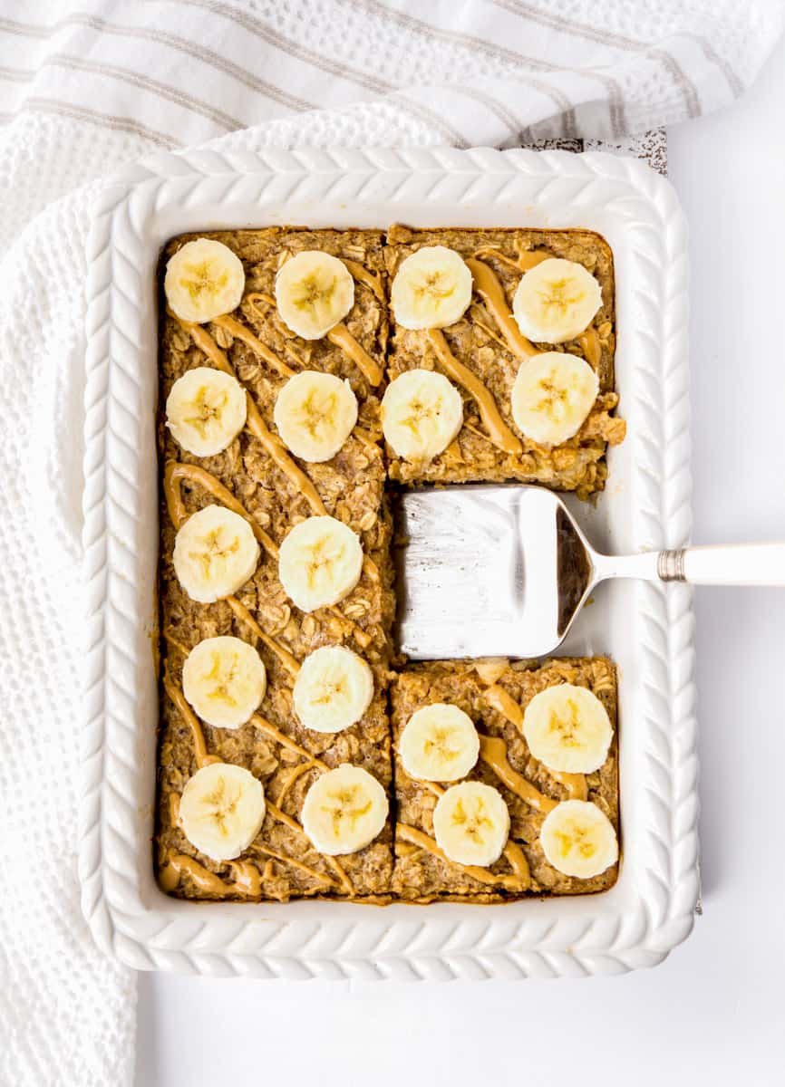 Peanut butter banana baked oatmeal in a baking dish with a spatula.