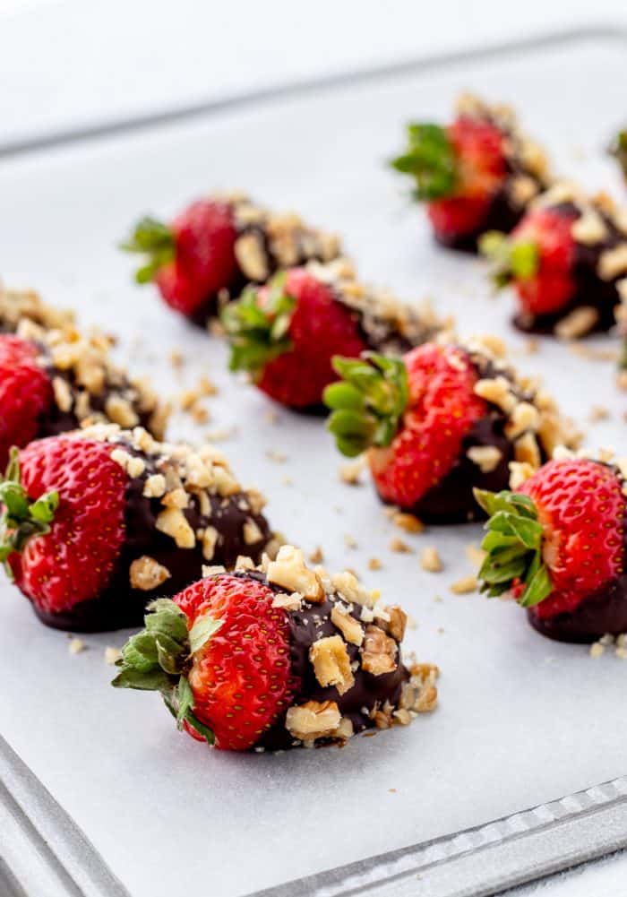 Strawberries dipped in dark chocolate and coated in walnuts.