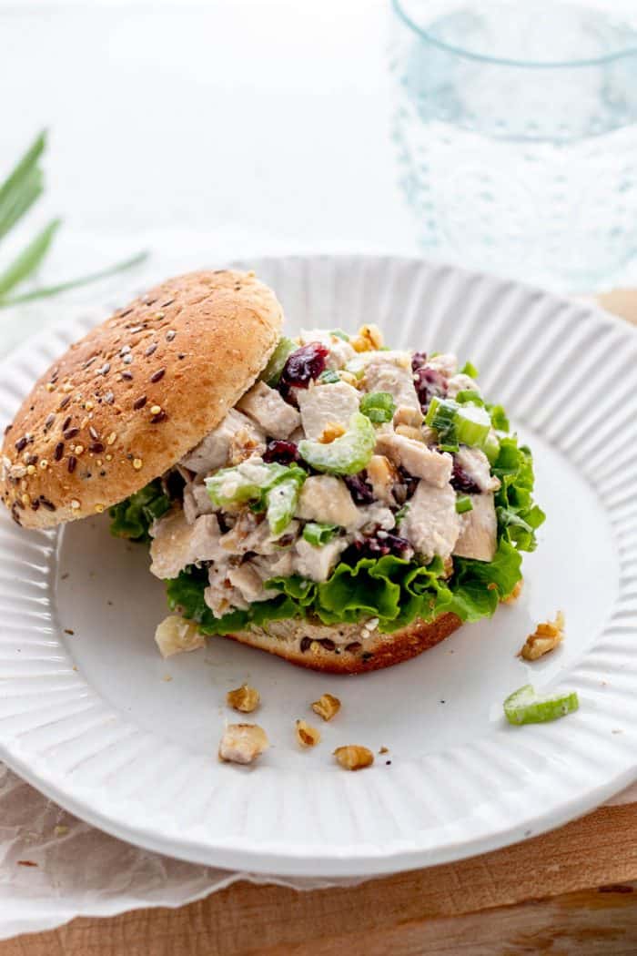 Cranberry chicken salad served in a bread roll with lettuce.