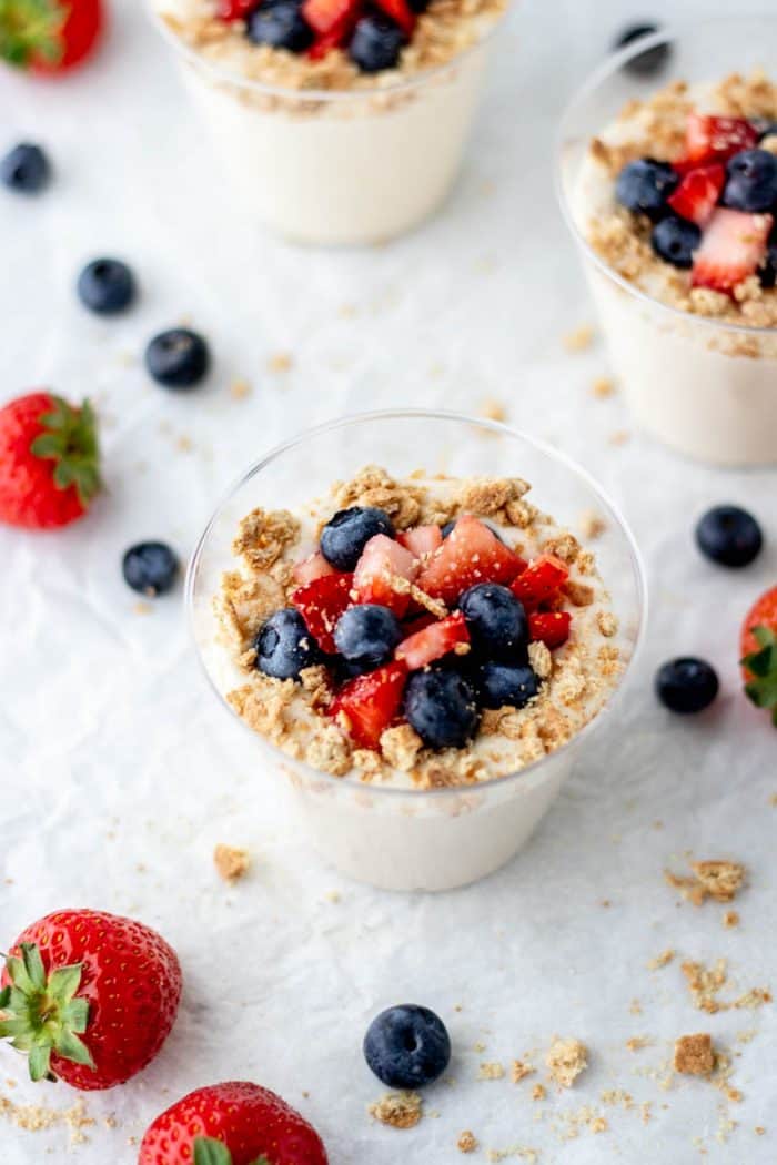 No bake cheesecake mix in a cup with berries and graham cracker crumbs.