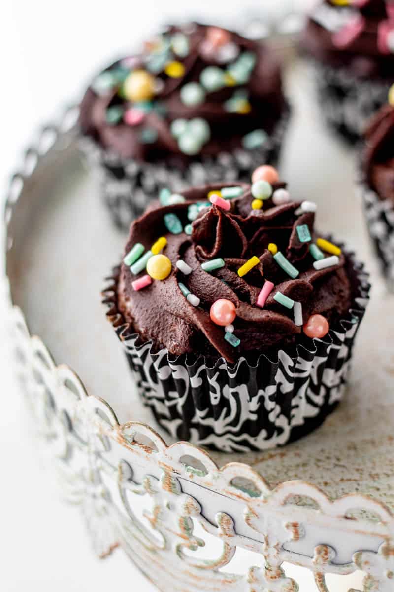 Healthy chocolate frosting on cupcakes topped with sprinkles.