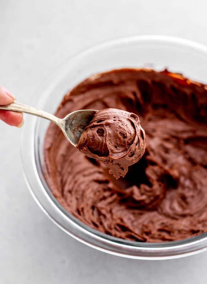 Chocolate coconut cream frosting on a spoon.