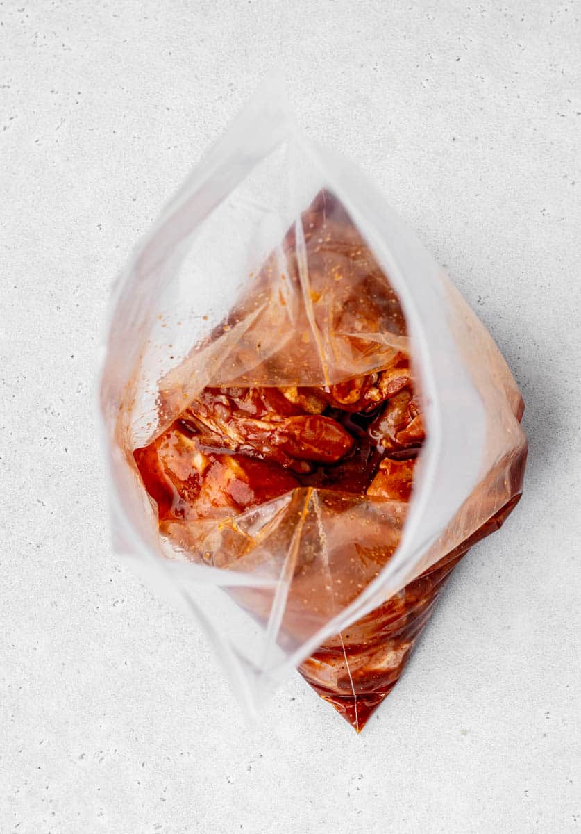 Skinless boneless chicken thighs in BBQ marinade in a resealable bag.