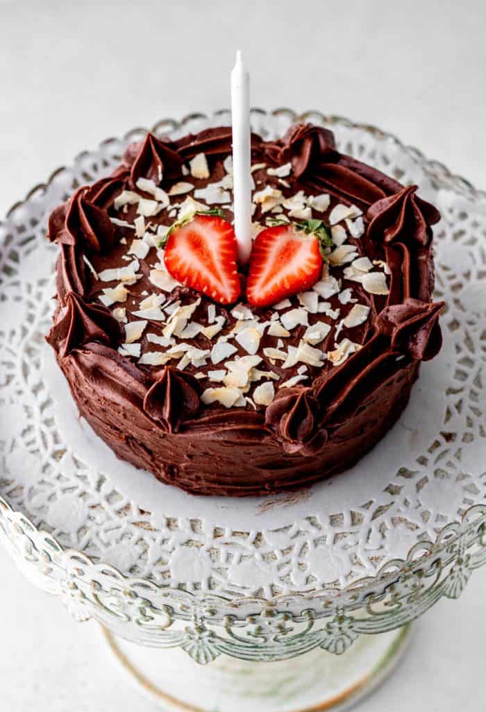 Refined sugar free birthday cake decorated with coconut flakes and strawberries.