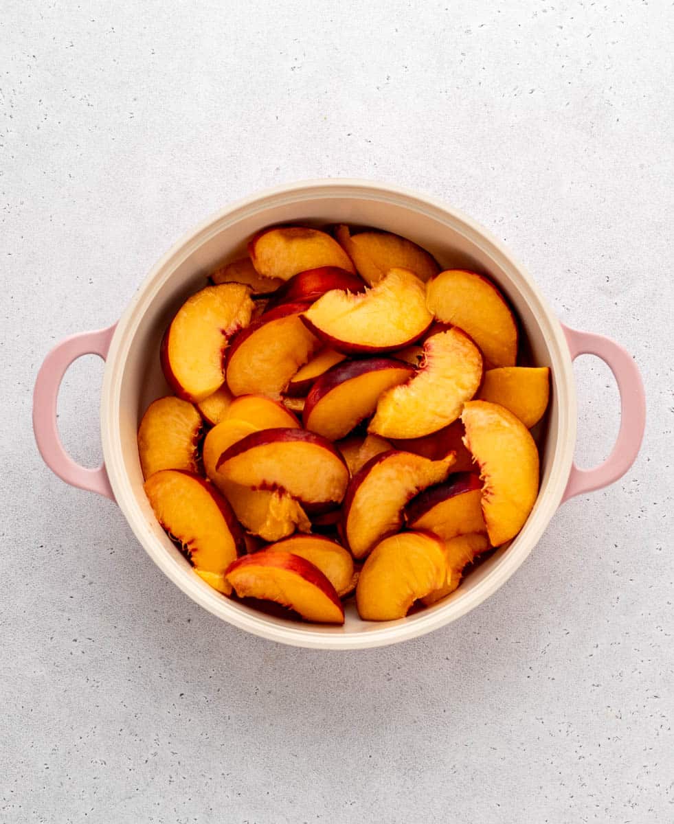 Slices of fresh peaches in a pot ready to be boiled.