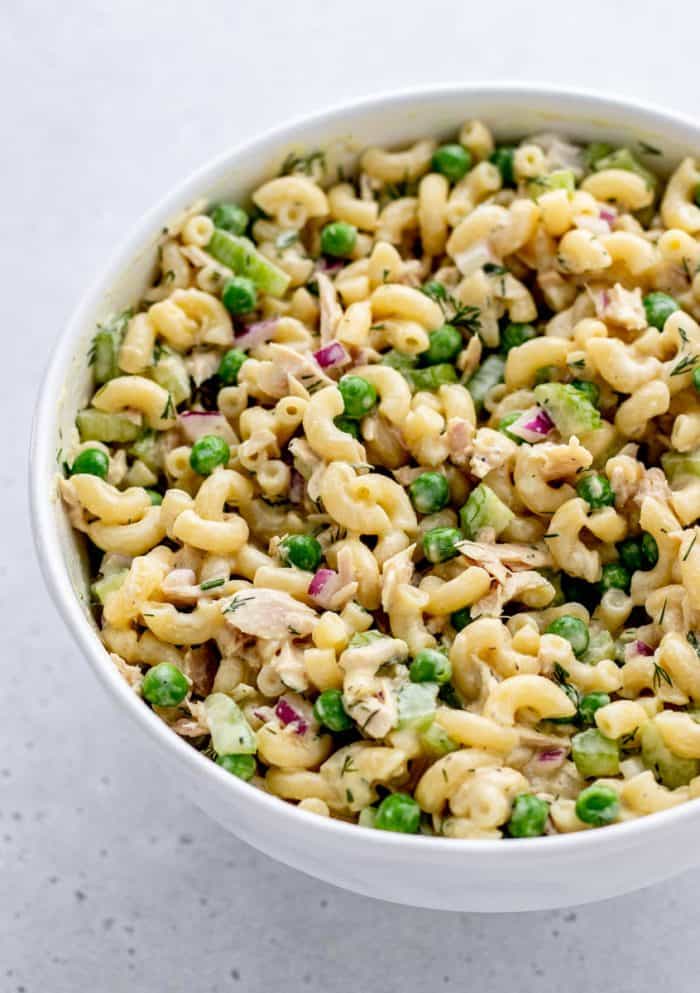 overhead image of tuna macaroni salad with peas, celery, and red onion tossed in a Greek yogurt and mayonnaise dressing