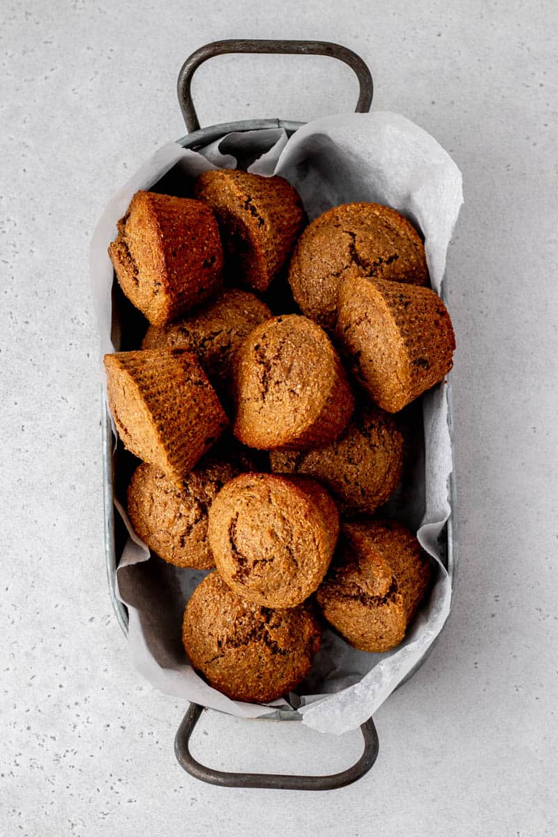A basket full of baked honey bran muffins.
