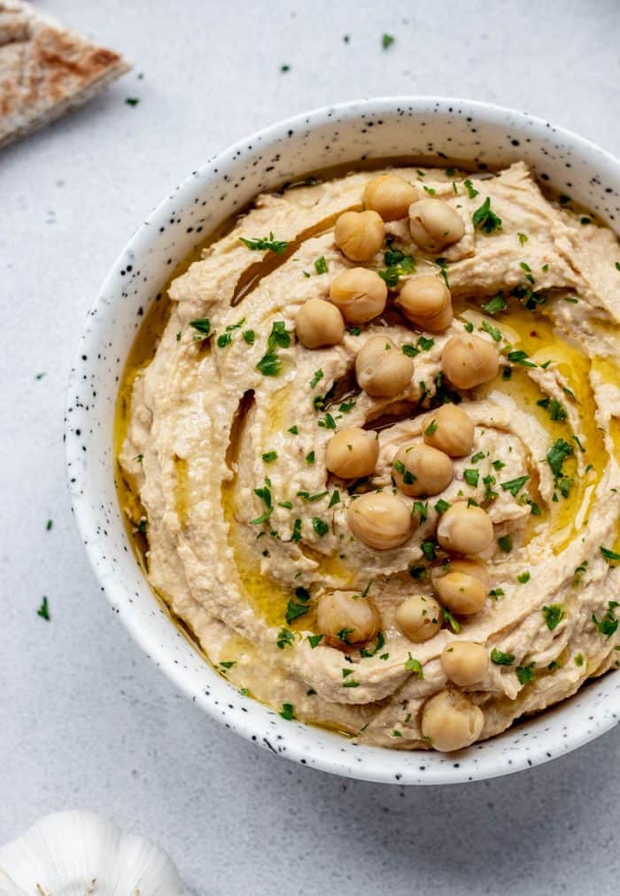 Roasted garlic hummus in a bowl topped with chickpeas.