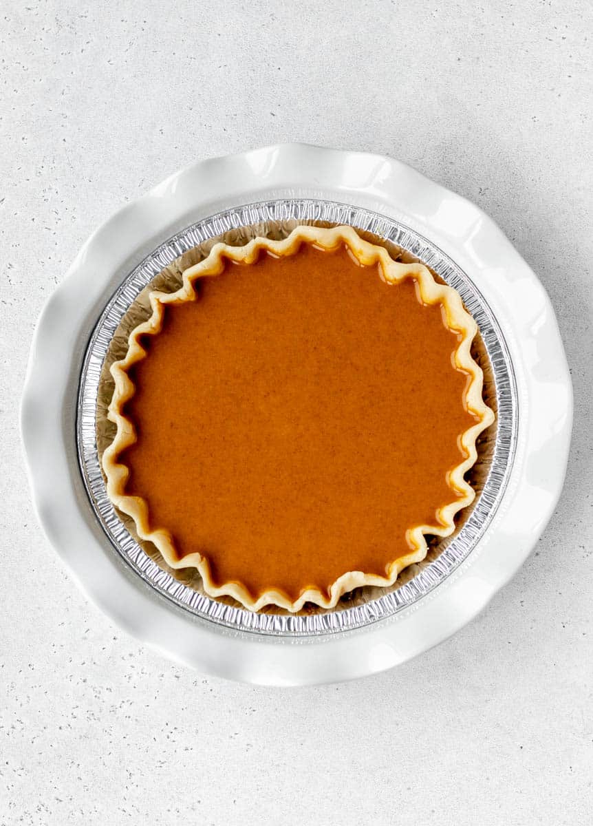 Overhead image of an unbaked almond milk pumpkin pie.