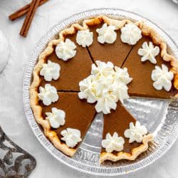 Overhead image of a baked easy pumpkin pie topped with dollops of whipped cream.