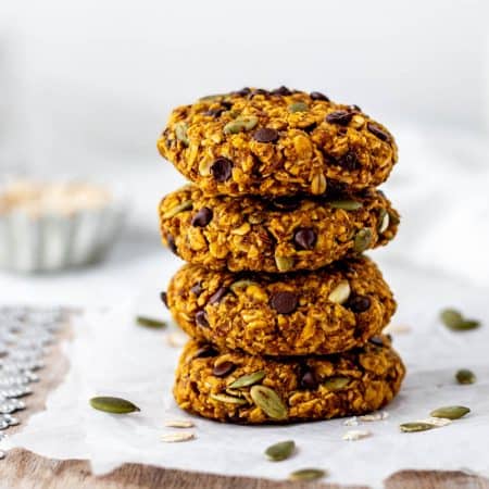 A stack of four pumpkin oatmeal chocolate chip cookies.