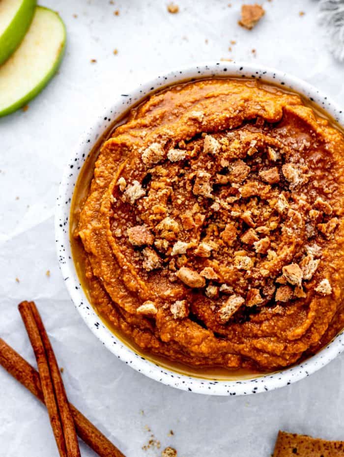 Overhead image of a bowl of healthy pumpkin pie hummus topped with graham cracker crumbs.