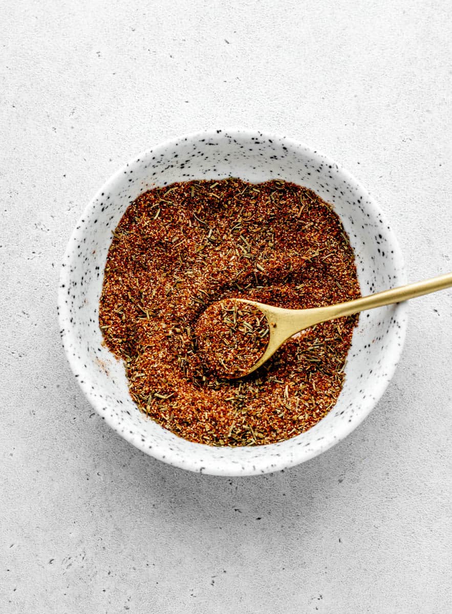An overhead image of a bowl of spices with a tablespoon scooping up a portion.