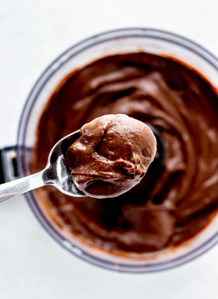 A spoonful of chocolate avocado pudding on a spoon.
