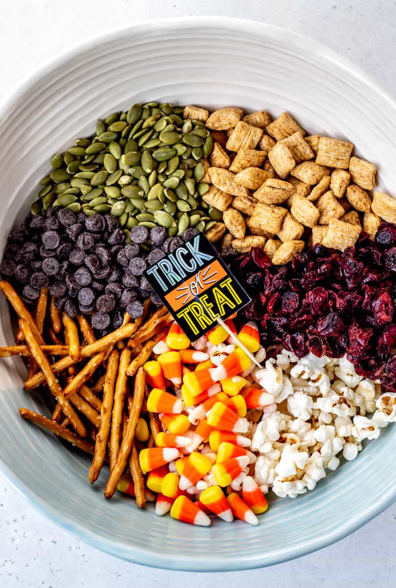 A bowl with the ingredients for the Halloween trail mix separated into sections.