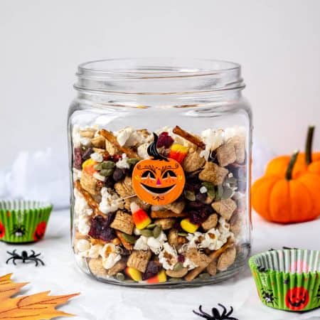 A large jar filled with Halloween trail mix.