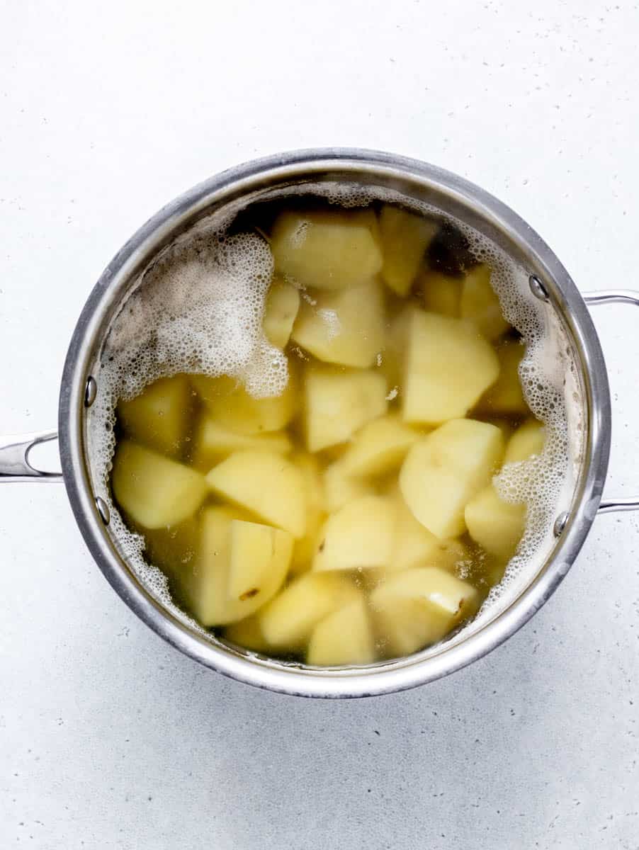 Diced potatoes covered with water in a sauce pan.