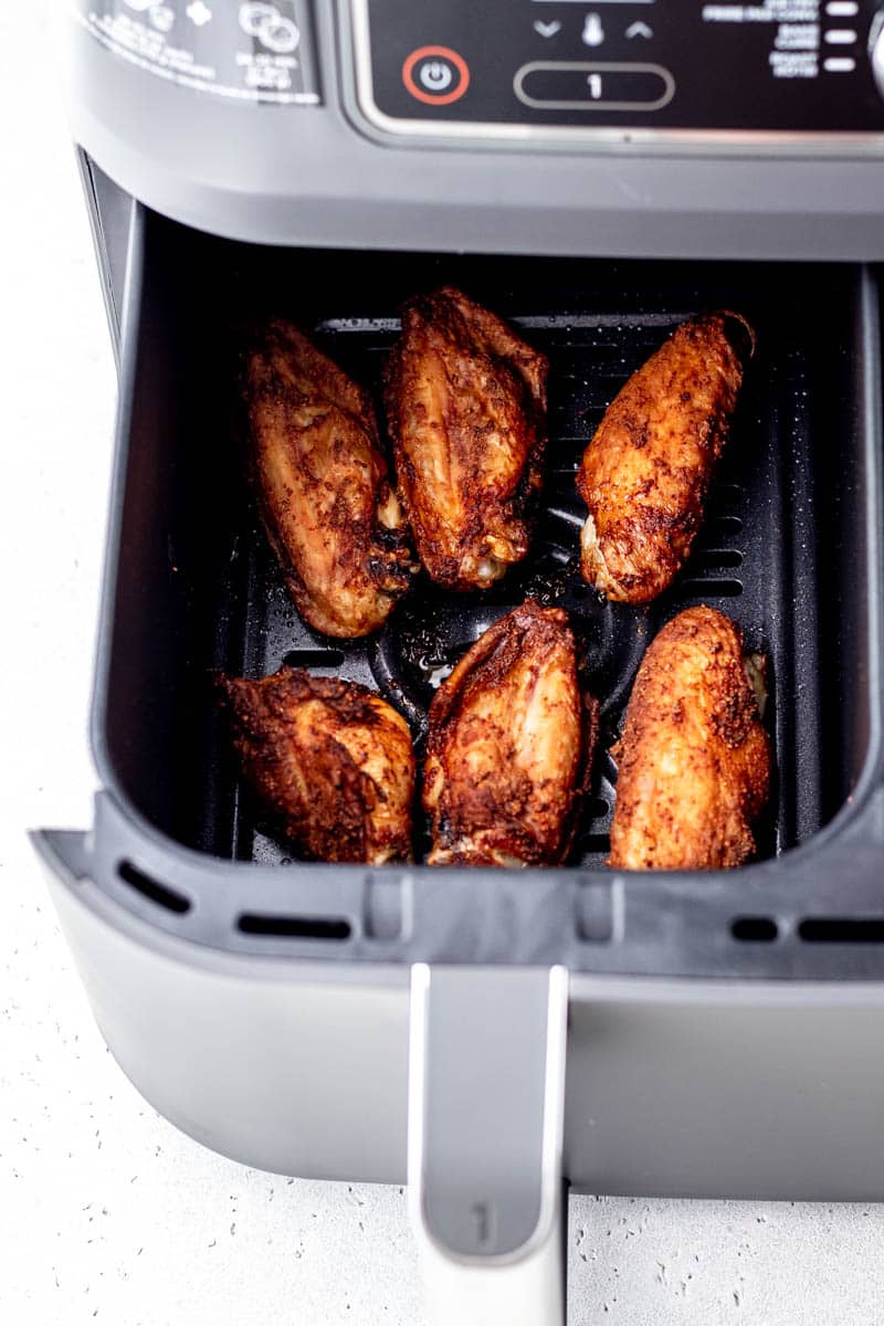 6 cooked chicken wings in an air fryer.