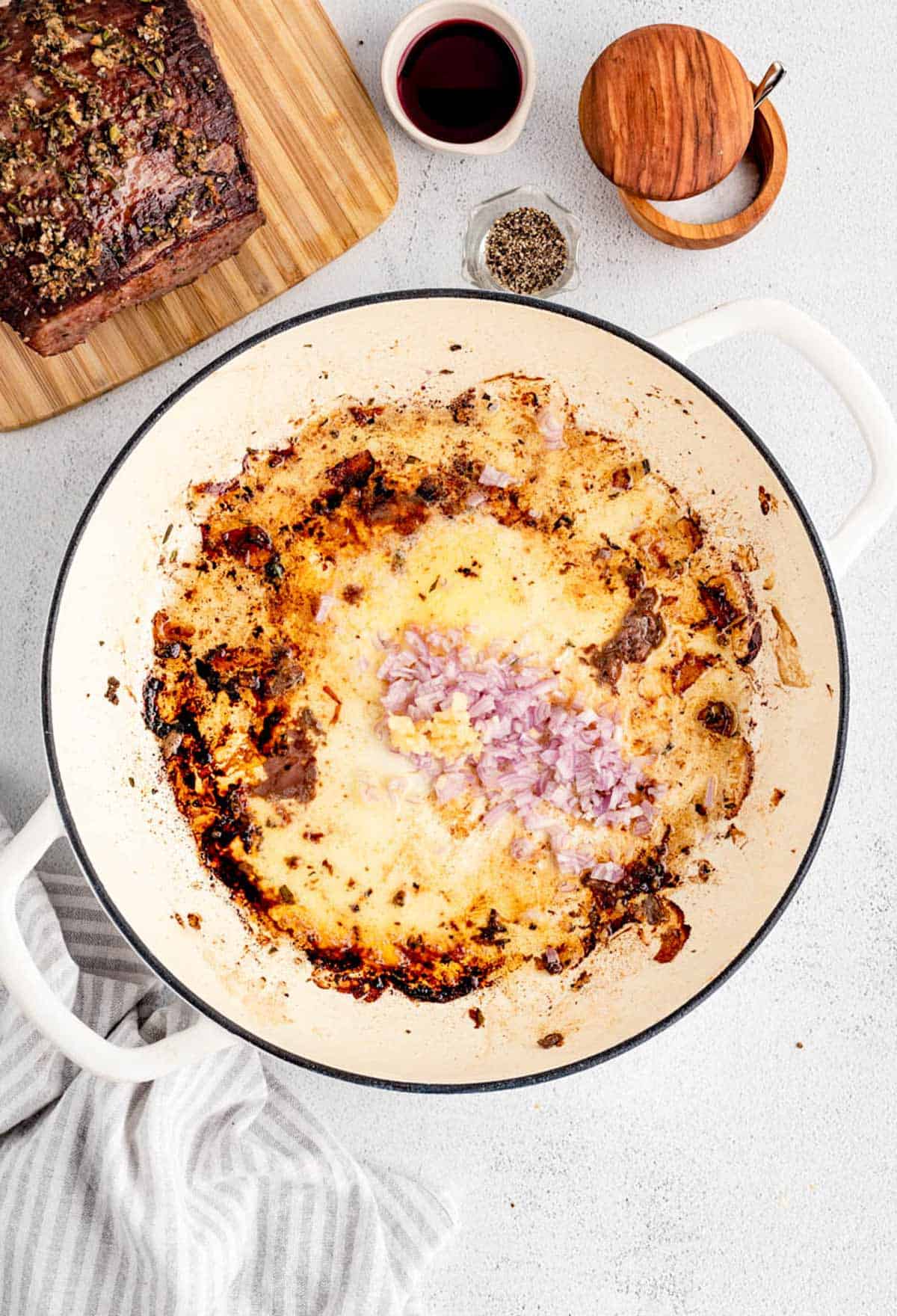 Uncooked shallots and garlic in the empty pot used to cook the eye of round holiday roast.
