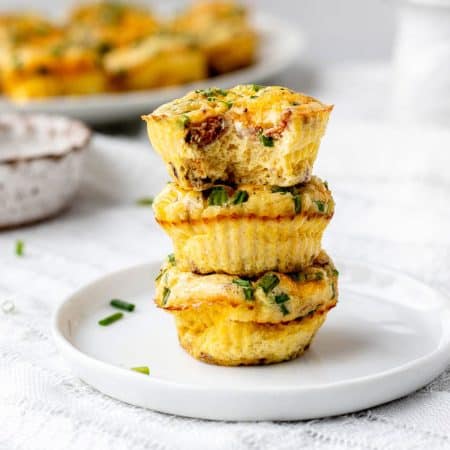 A stack of 3 mini crustless quiches on a white plate.