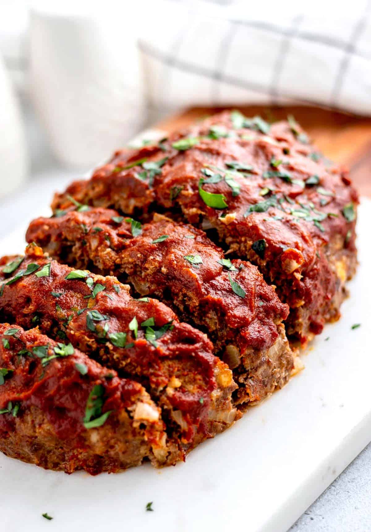 5 ingredient baked meatloaf sliced and ready to be served.