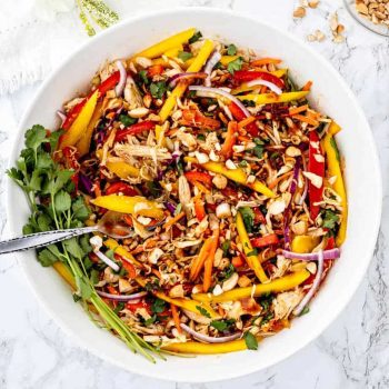 Thai mango chicken salad in a large bowl with a fork.