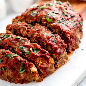 Baked 5 ingredient meatloaf sliced on a cutting board.