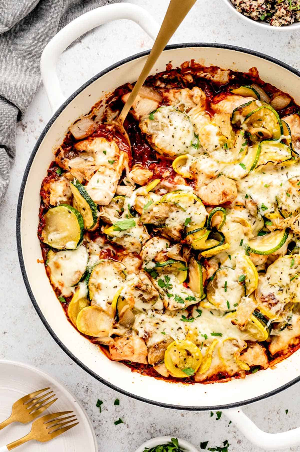 Chicken zucchini casserole in a Dutch oven with a serving spoon in it.