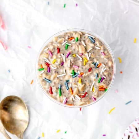High protein birthday cake overnight oats in a cup topped with sprinkles.