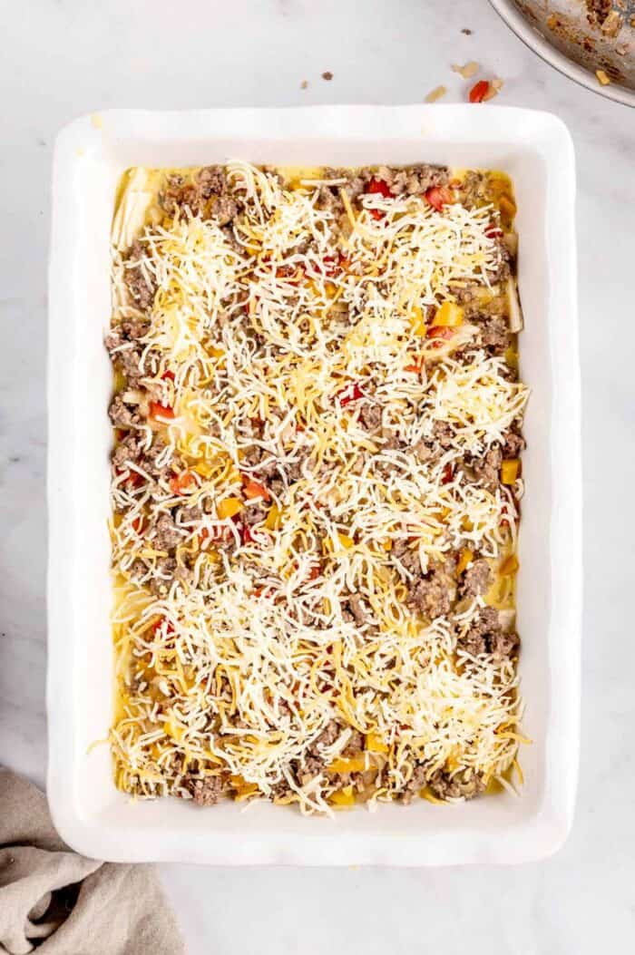 The burrito breakfast casserole sprinkled with cheese ready to go in the oven.
