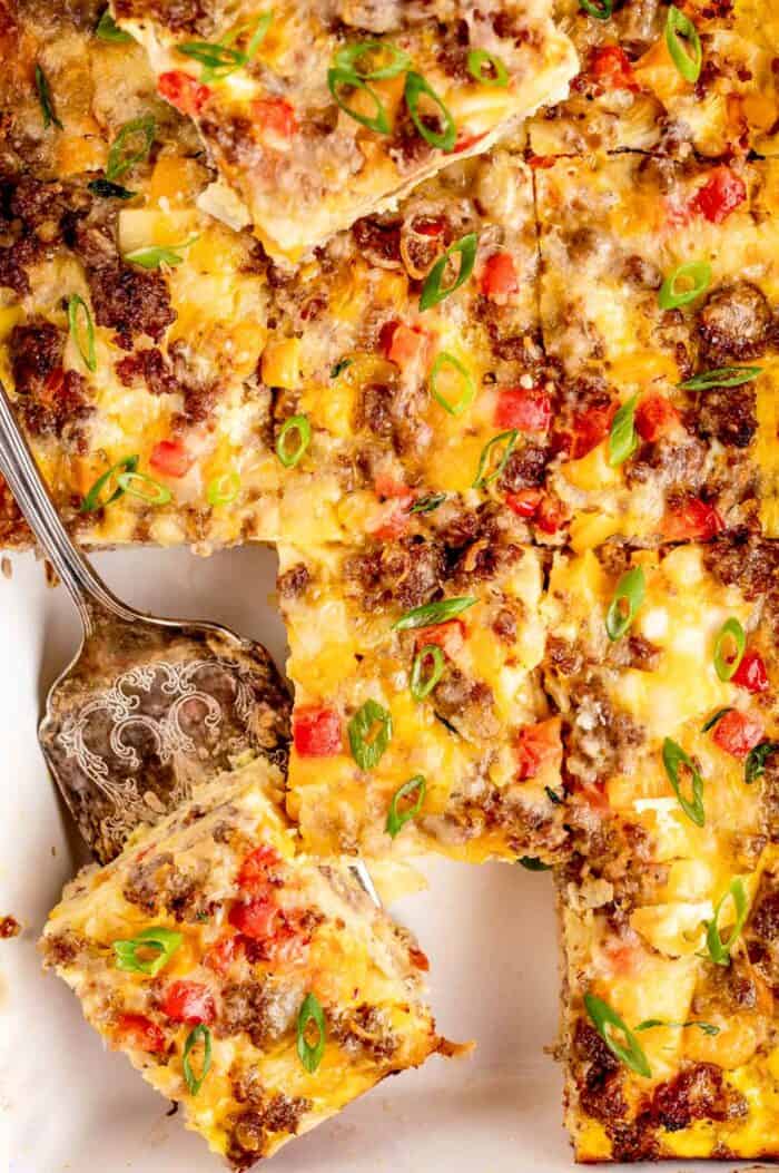 Overhead image of a spatula picking up a piece of the breakfast burrito casserole.