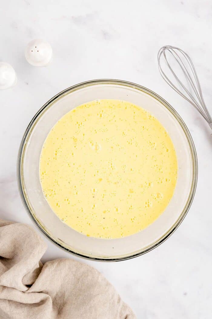 The egg mixture whisked together in a bowl for the breakfast burrito casserole.