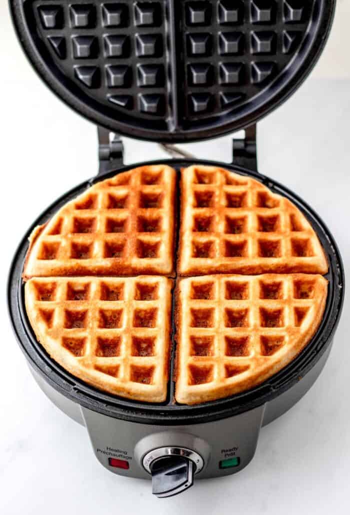 Almond flour waffles being cooked in a waffle maker.