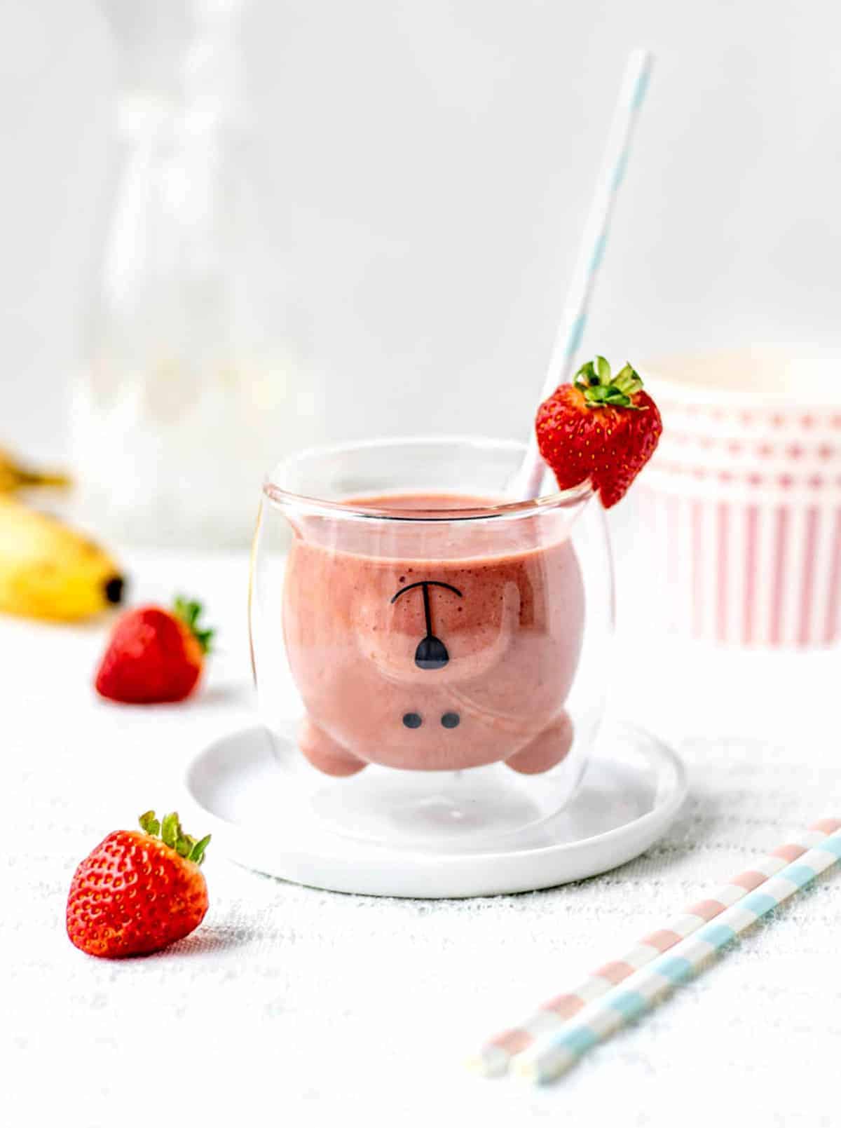 A strawberry banana smoothie in a teddy bear cup.
