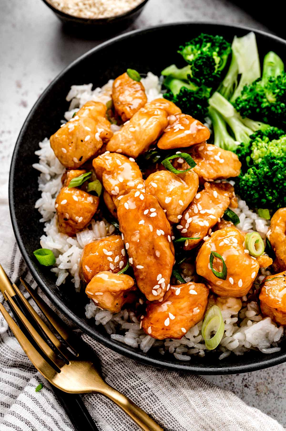 Healthy honey sesame chicken served over rice with steamed broccoli.