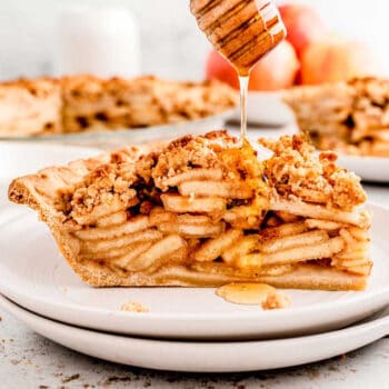 A honey dipper drizzling honey on a slice of healthier apple pie.