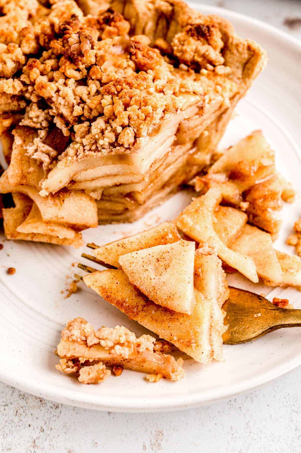 A fork picking up some healthier apple pie on a plate.