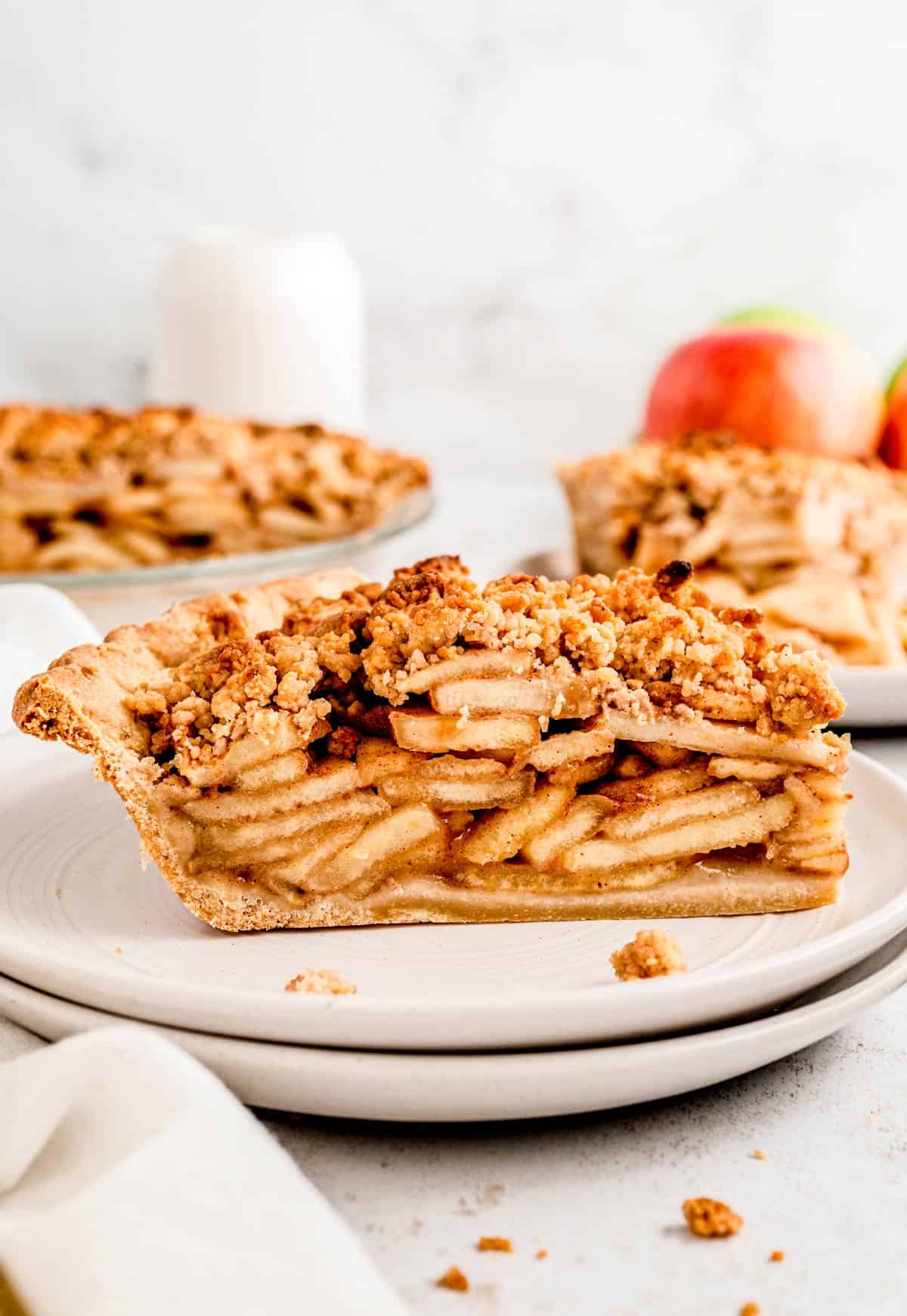 A slice of healthy apple pie on two stacked plates.