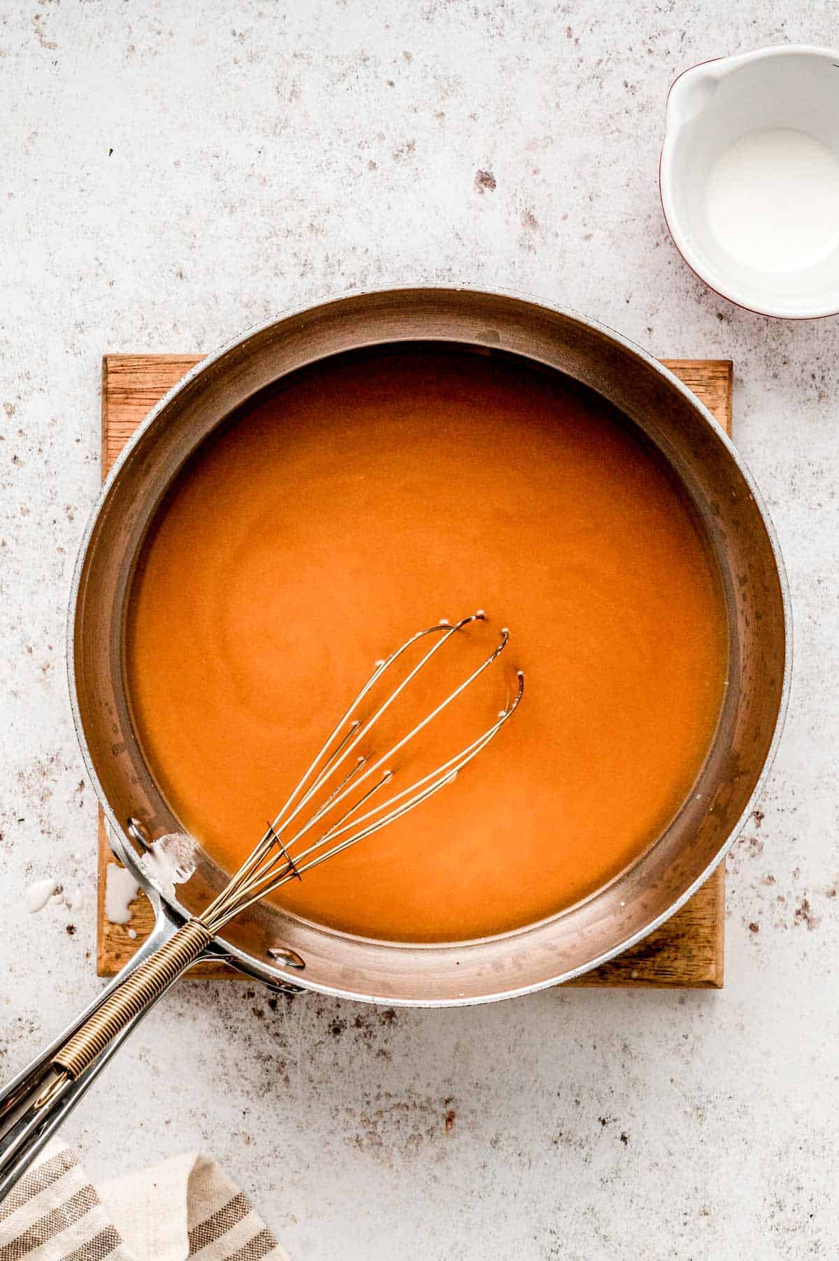 A whisk in a pot of gravy.